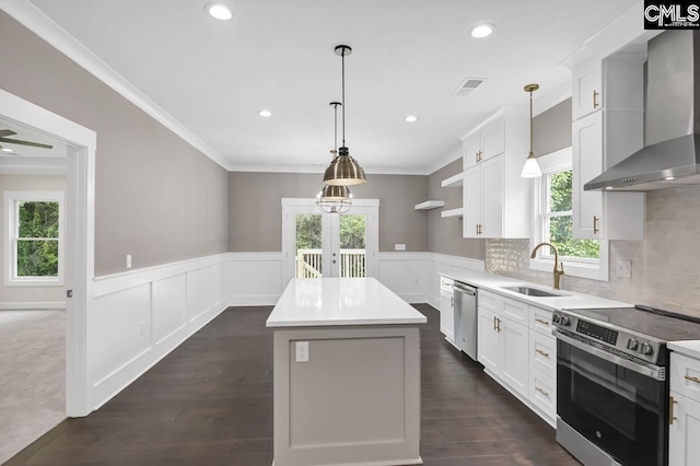 1409 Woodrow St, Columbia, SC 29205 - kitchen featuring stainless steel appliances, wall chimney exhaust hood, a sink, healthy amount of natural light, and a wainscoted wall