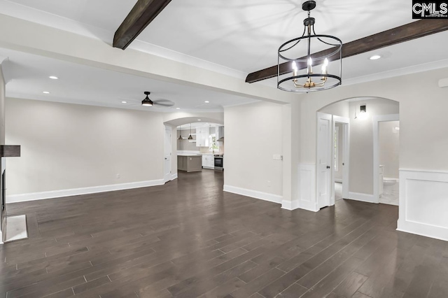 1409 Woodrow St, Columbia, SC 29205 - unfurnished living room with arched walkways, beamed ceiling, a chandelier, dark wood-type flooring, and ceiling fan