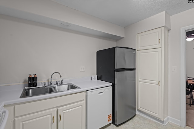 1825 Saint Julian Pl Unit 4E, Columbia, SC 29204 - kitchen featuring white dishwasher, a sink, freestanding refrigerator, white cabinets, and light countertops