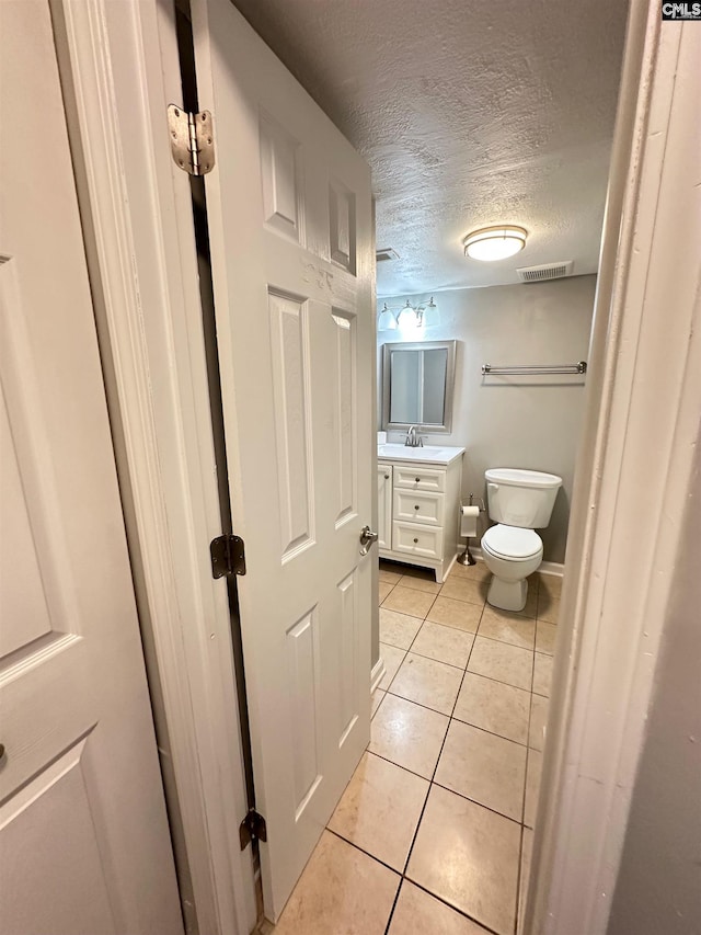 1201 Old Manor Rd, Columbia, SC 29210 - half bath featuring a textured ceiling, toilet, tile patterned flooring, vanity, and baseboards