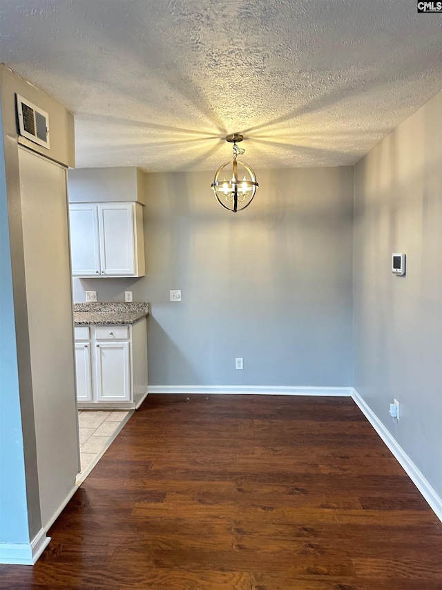 1201 Old Manor Rd, Columbia, SC 29210 - kitchen featuring white cabinetry, a textured ceiling, wood finished floors, a chandelier, and baseboards