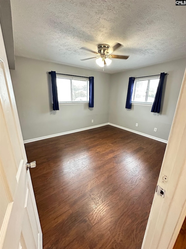 1201 Old Manor Rd, Columbia, SC 29210 - empty room with a textured ceiling, ceiling fan, dark wood-type flooring, and baseboards
