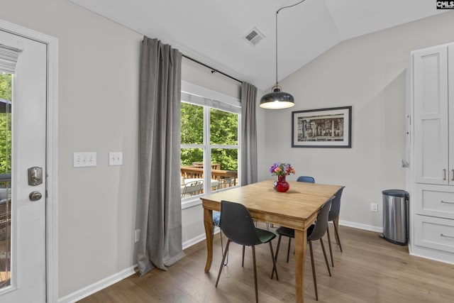 dining area featuring vaulted ceiling, healthy amount of natural light, light wood-type flooring, and baseboards