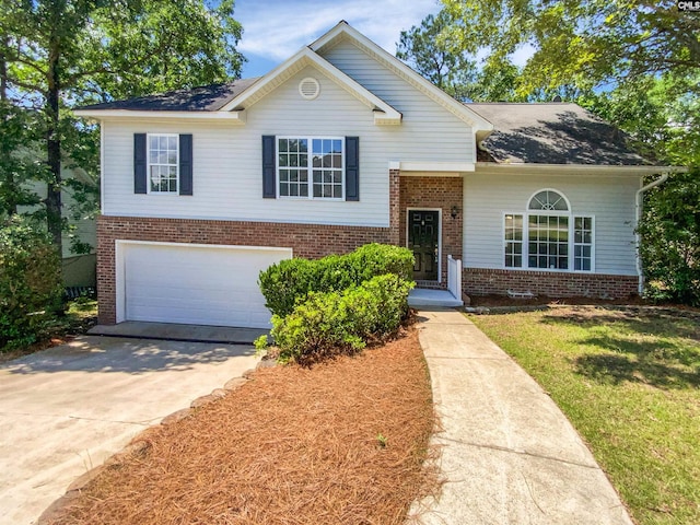tri-level home featuring brick siding, a garage, concrete driveway, a front lawn, and roof with shingles