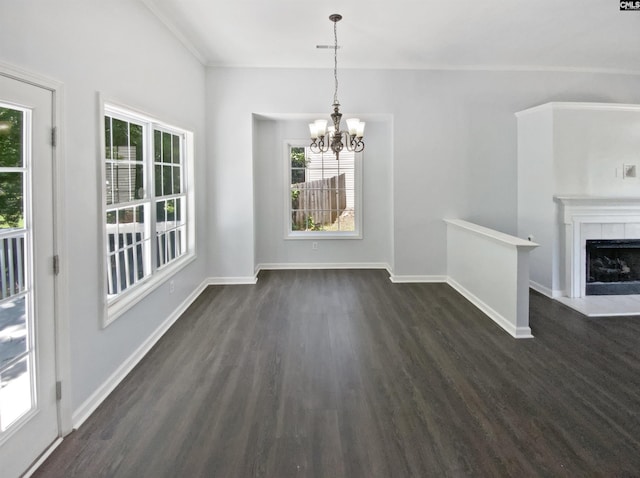 unfurnished dining area with dark wood-type flooring, healthy amount of natural light, a chandelier, and baseboards