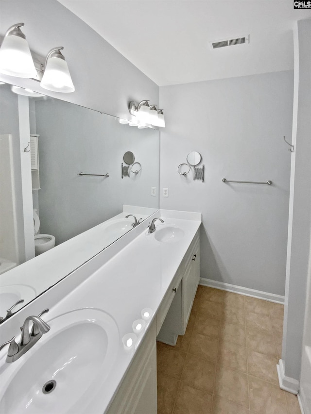 full bath with double vanity, tile patterned flooring, baseboards, and toilet