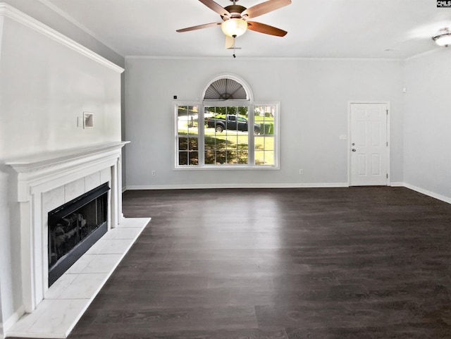 unfurnished living room featuring crown molding, a ceiling fan, a tiled fireplace, baseboards, and wood finished floors
