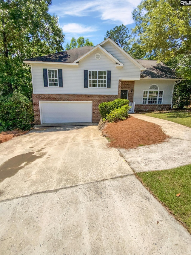 view of front facade with brick siding, a garage, and concrete driveway
