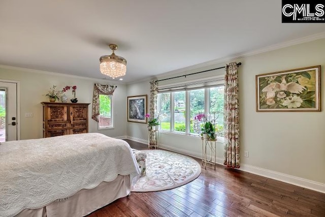 bedroom with baseboards, ornamental molding, wood finished floors, and a chandelier