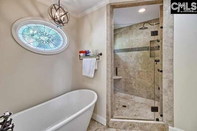 bathroom featuring a shower stall, a chandelier, a freestanding tub, ornamental molding, and baseboards