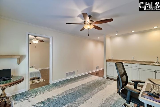 office area with a ceiling fan, crown molding, wood finished floors, baseboards, and wet bar