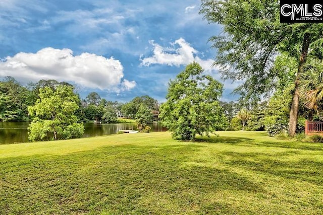 view of green lawn with a water view