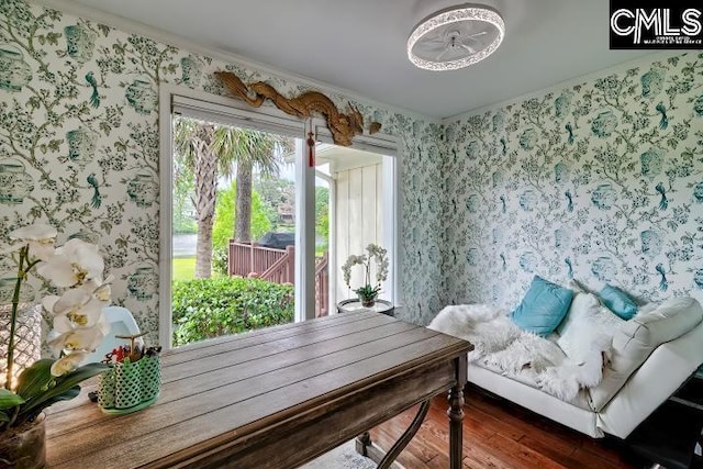 living area with wallpapered walls and hardwood / wood-style floors