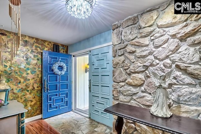 entrance foyer with baseboards and wallpapered walls