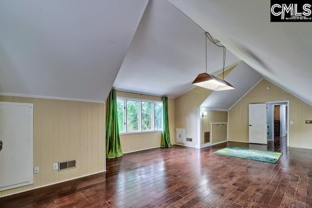 additional living space with wood finished floors and vaulted ceiling