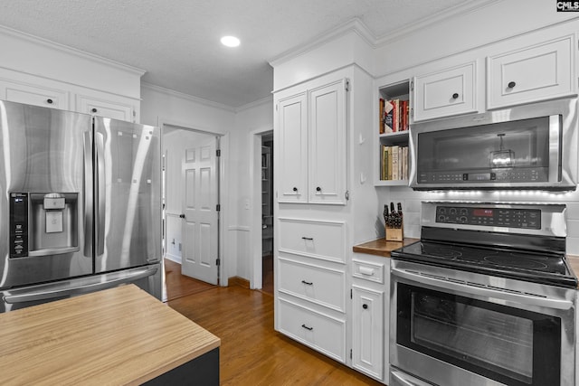 kitchen featuring stainless steel appliances, wood finished floors, crown molding, white cabinets, and a textured ceiling