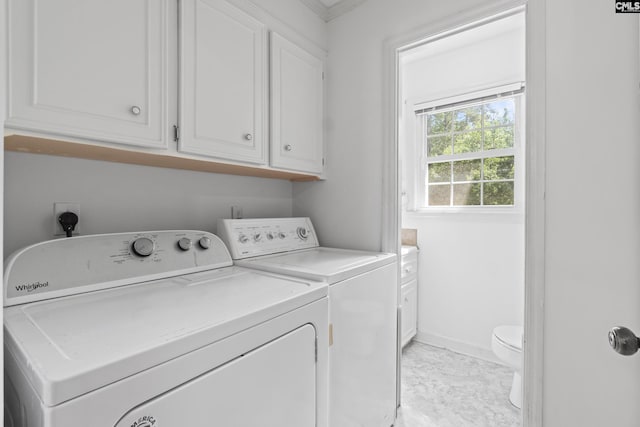 clothes washing area with washer and dryer and baseboards