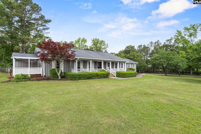 single story home featuring a porch, a front lawn, a chimney, and a sunroom