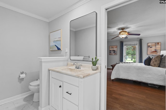 bedroom featuring a sink, baseboards, ornamental molding, ensuite bathroom, and a ceiling fan