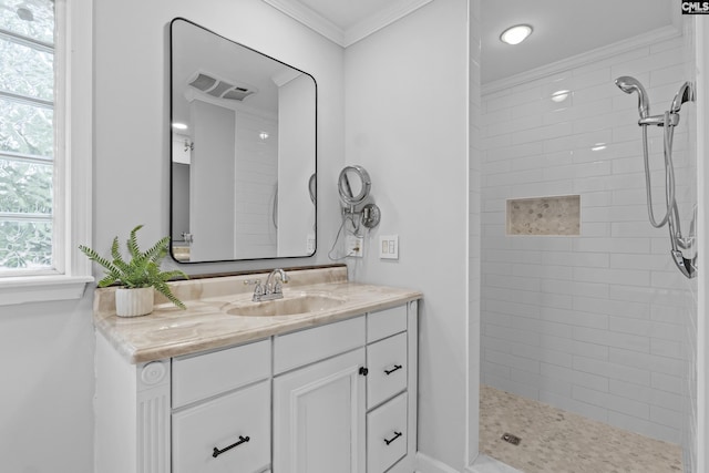 full bath featuring crown molding, tiled shower, and vanity