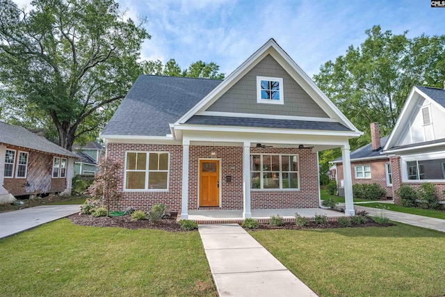 1020 W Confederate Ave, Columbia, SC 29201 - view of front of house with covered porch, brick siding, a front lawn, and roof with shingles
