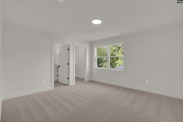 1020 W Confederate Ave, Columbia, SC 29201 - unfurnished bedroom with light colored carpet, baseboards, and a walk in closet