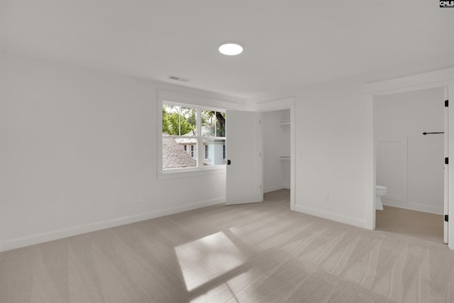 1020 W Confederate Ave, Columbia, SC 29201 - unfurnished bedroom with light colored carpet, a walk in closet, baseboards, ensuite bath, and a closet