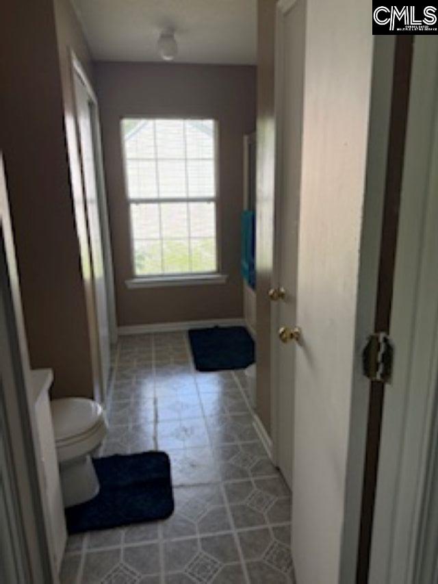 bathroom featuring toilet and baseboards