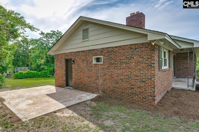 3901 Overdale Dr, Columbia, SC 29223 - view of home's exterior featuring a patio, brick siding, and a chimney