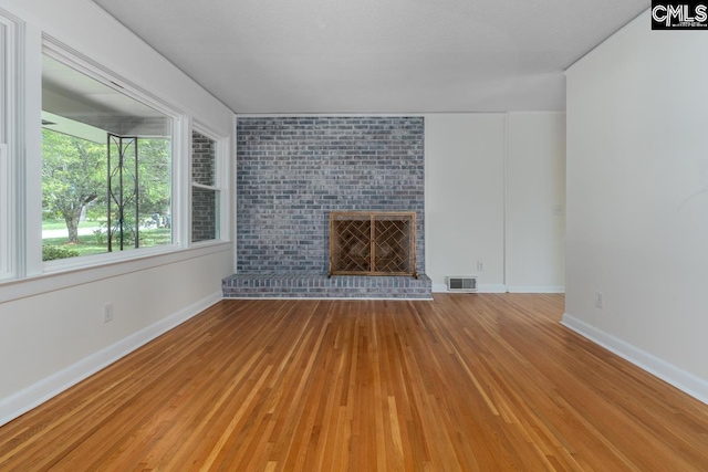 3901 Overdale Dr, Columbia, SC 29223 - unfurnished living room featuring light wood-type flooring, baseboards, and a brick fireplace