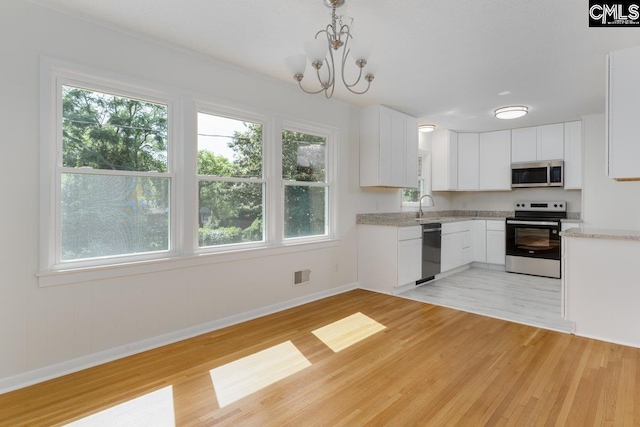 3901 Overdale Dr, Columbia, SC 29223 - kitchen with appliances with stainless steel finishes, baseboards, a sink, and light wood-type flooring