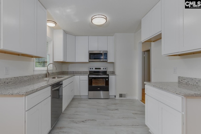 3901 Overdale Dr, Columbia, SC 29223 - kitchen featuring appliances with stainless steel finishes, a sink, light marble finish floors, and light stone counters