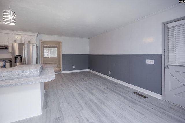 969 Boulevard Rd, Sumter, SC 29153 - kitchen with appliances with stainless steel finishes, light countertops, white cabinets, decorative light fixtures, and light wood-style flooring