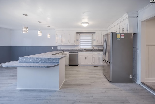 969 Boulevard Rd, Sumter, SC 29153 - kitchen with appliances with stainless steel finishes, a peninsula, white cabinetry, light wood-type flooring, and ornamental molding