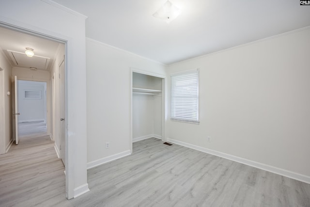 969 Boulevard Rd, Sumter, SC 29153 - unfurnished bedroom with attic access, light wood-type flooring, baseboards, crown molding, and a closet