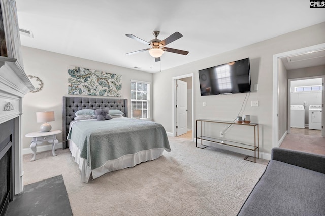 carpeted bedroom featuring washer and clothes dryer, a fireplace with flush hearth, ceiling fan, and baseboards