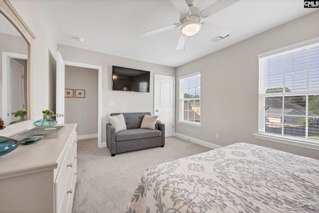 bedroom with light colored carpet, baseboards, and ceiling fan