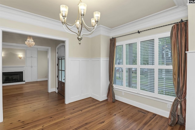 177 Preserve Ln, Columbia, SC 29209 - unfurnished dining area featuring a chandelier, crown molding, wood finished floors, wainscoting, and a fireplace