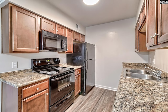 516 Menlo, Columbia, SC 29210 - kitchen with black appliances, a sink, light wood-type flooring, baseboards, and brown cabinetry