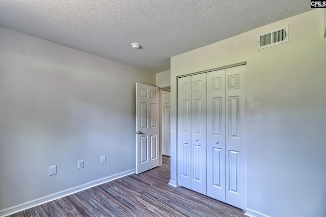 516 Menlo, Columbia, SC 29210 - unfurnished bedroom with dark wood-style floors, baseboards, a closet, and a textured ceiling