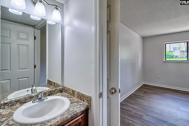 516 Menlo, Columbia, SC 29210 - bathroom with a textured ceiling, wood finished floors, baseboards, and vanity