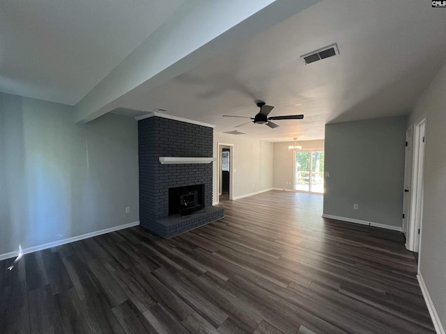 unfurnished living room featuring ceiling fan, dark wood-style flooring, baseboards, a fireplace, and a chandelier