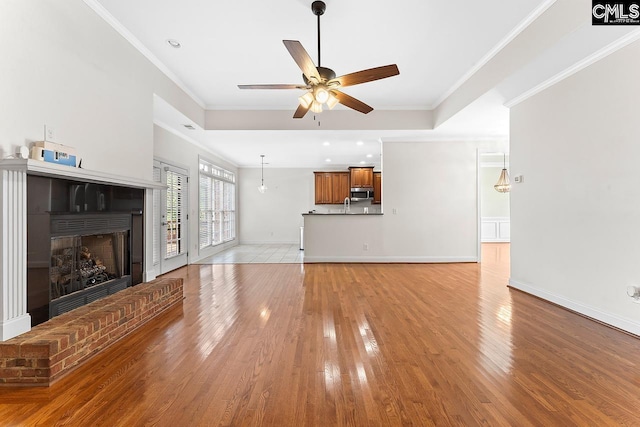 203 Savannah Branch Trl, Irmo, SC 29063 - unfurnished living room featuring ceiling fan, light wood finished floors, crown molding, baseboards, and a fireplace