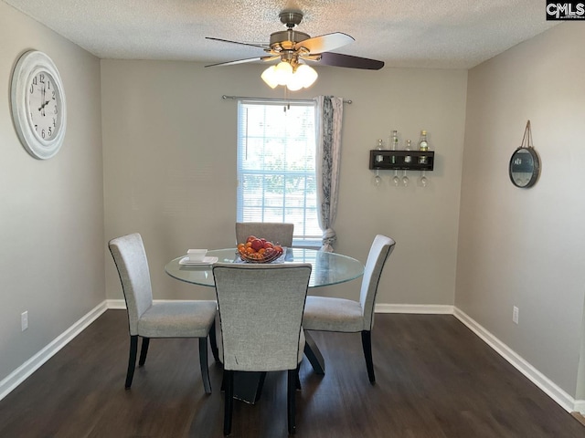 dining room with dark wood finished floors, ceiling fan, a textured ceiling, and baseboards
