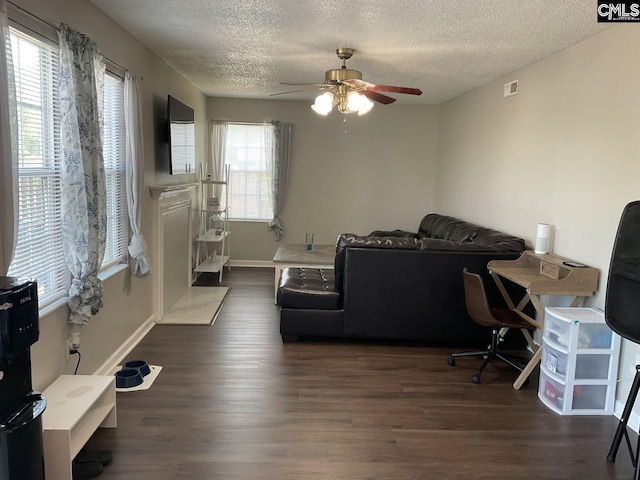 office space with ceiling fan, a textured ceiling, wood finished floors, and baseboards
