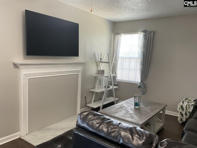 living area featuring a textured ceiling and baseboards