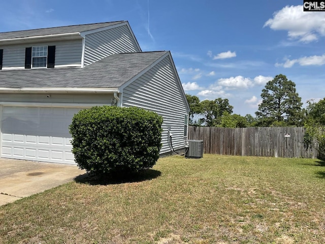 view of side of property with a garage, concrete driveway, and cooling unit