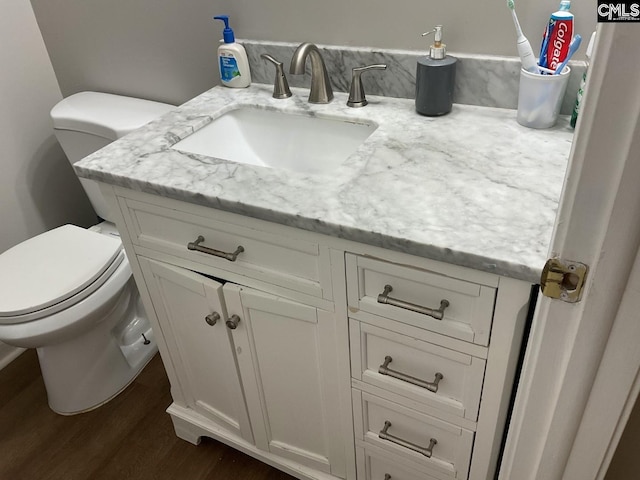 bathroom featuring vanity, toilet, and wood finished floors