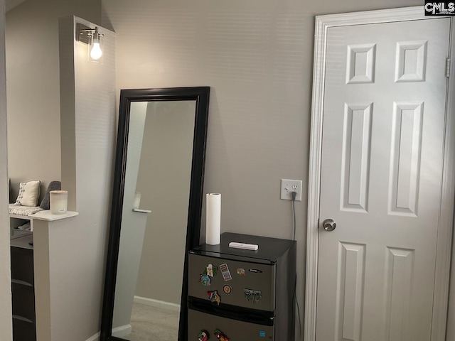 bedroom with baseboards, freestanding refrigerator, and carpet floors