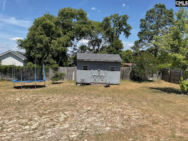 view of yard with a trampoline, a storage shed, and an outdoor structure
